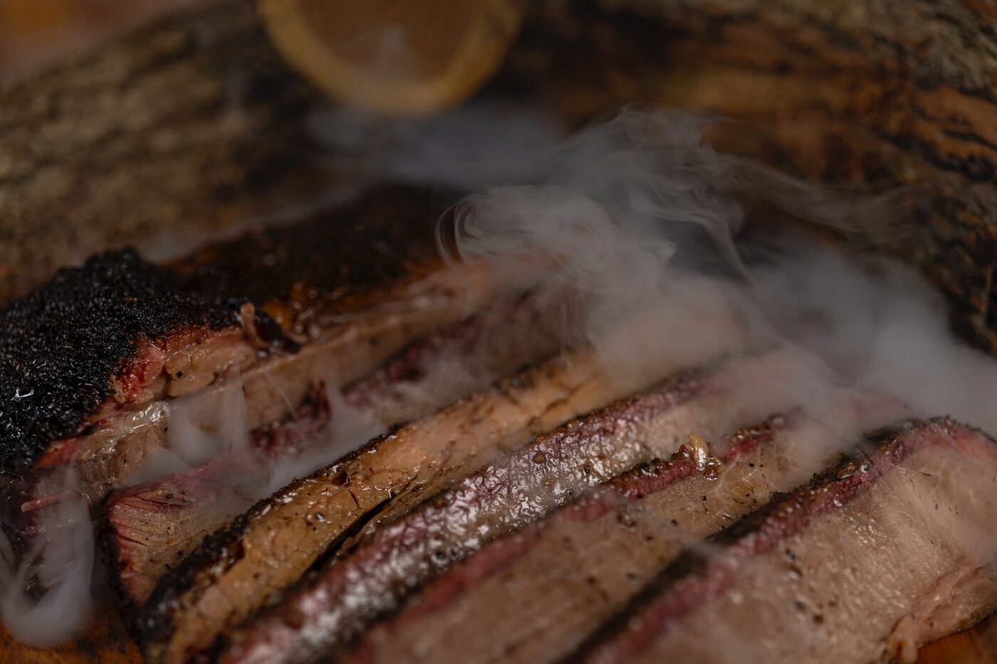 Sliced brisket with smoke photographed for Uprise BBQ